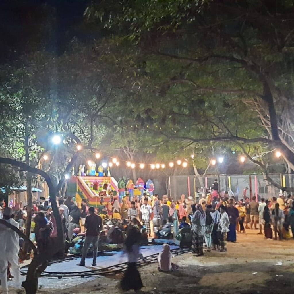 Suasana malam di Pantai THB Bringsang dengan lampu hias, angin laut, dan ayunan yang menciptakan tempat ngabuburit favorit warga Giligenting