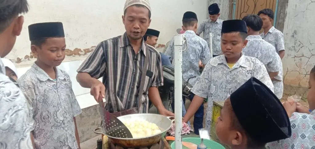 Pak Junai saat melayani pembeli tahu kres dan pentol tahu di sekitar sekolah Nurul Yaqin, Sumenep