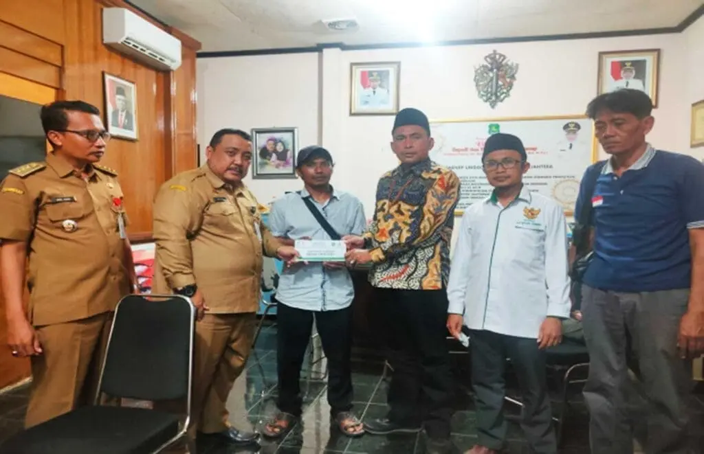 Ketua Baznas dan Dinsos P3A Sumenep saat menyerahkan santunan kepada keluarga korban kebakaran depo Plumpang asal Desa Gedugan, Giligenting