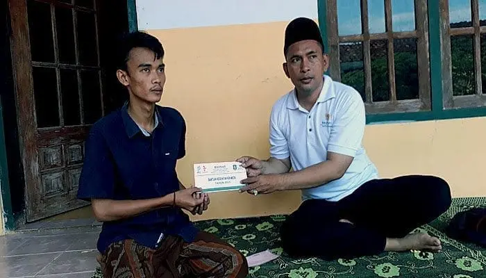 Ketua Baznas Kabupaten Sumenep, M. Sukri saat menyerahkan bantuan