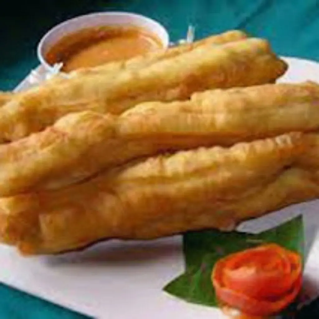 Cakwe goreng yang renyah dan empuk, disajikan dengan saus pedas menggoda, siap untuk dinikmati sebagai camilan atau pelengkap sarapan