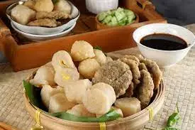 Pempek Sutra Udang dengan Cuko Pedas: Pempek sutra bertekstur lembut, terbuat dari udang segar dan tepung tapioka, disajikan dengan kuah cuko pedas yang khas. Cuko ini dibuat dari gula merah, cabe rawit, dan bumbu rempah lainnya yang membuat rasanya semakin sedap