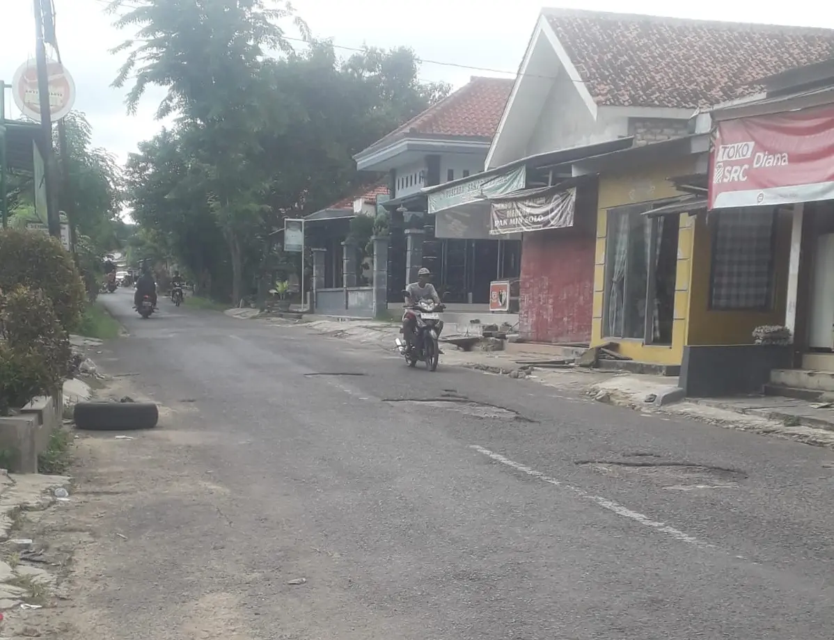 Kondisi jalan poros Bluto-Moncek yang rusak parah dengan lubang besar, membahayakan pengendara yang melintas