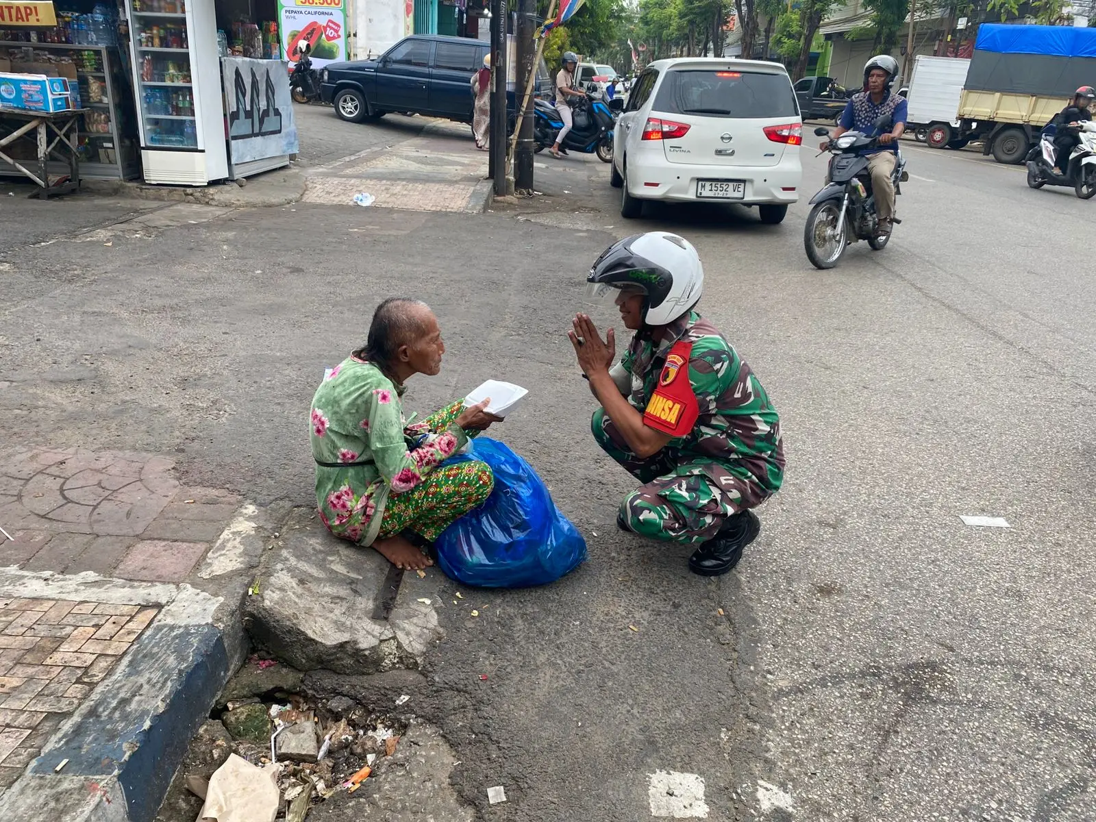 Babinsa Koramil 0827/01 Kota membagikan nasi kotak gratis kepada warga kurang mampu di Sumenep dalam kegiatan Jumat Berkah