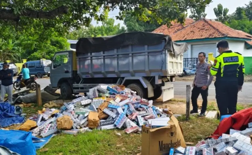Petugas mengevakuasi dump truk muatan rokok yang terguling usai tabrakan dengan mobil Traga di Jalan Raya Rabiyan, Sampang, Rabu (18/6/2025) dini hari