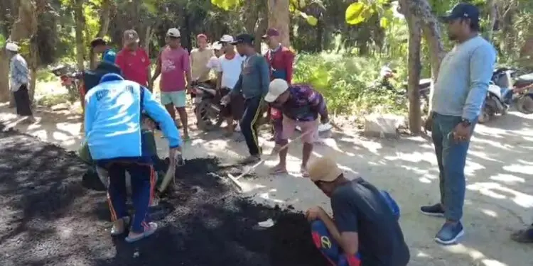 Warga Dusun Julung, Desa Galis, Kecamatan Giligenting, Kabupaten Sumenep saat Aspal jalan secara swadaya