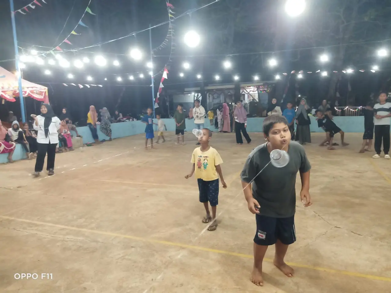 Para peserta lomba tiup gelas tengah konsentrasi untuk menjadi juara pada malam kedua perayaan HUT ke-80 RI 2025