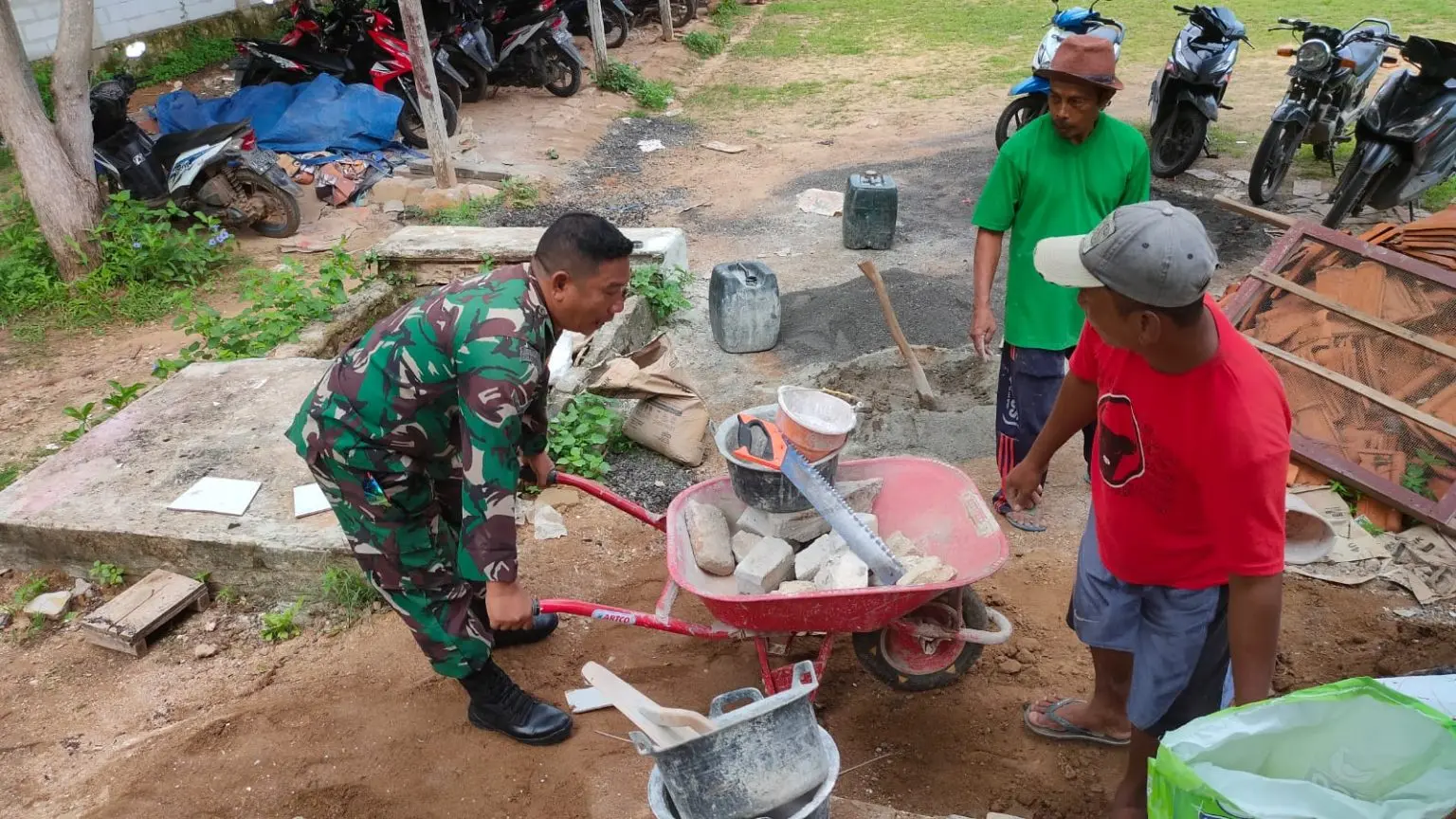 Babinsa Koramil Sapudi Serda Alam membantu warga Desa Rongsong Sumenep dalam pembangunan rumah secara gotong royong