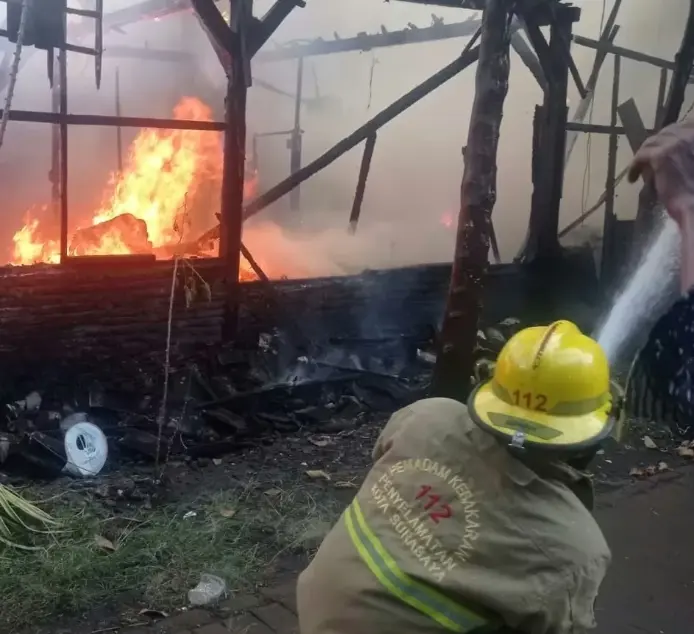 Petugas pemadam kebakaran Surabaya memadamkan rumah terbakar di Jalan Lakarsantri akibat dugaan korsleting listrik