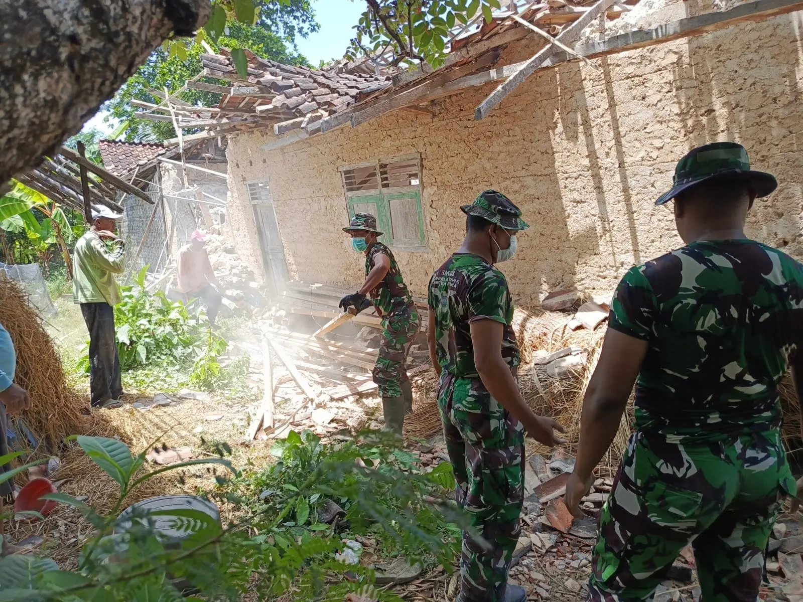 TNI Kodim 0827 Sumenep membantu warga Pulau Sapudi membersihkan puing rumah rusak akibat gempa bumi