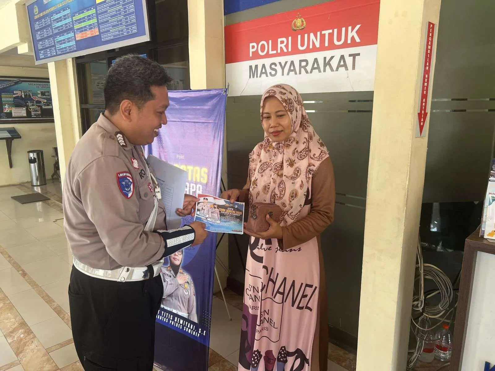 Petugas Satlantas Polres Sumenep memberikan sosialisasi keselamatan berkendara kepada warga dalam program Polantas Menyapa Operasi Zebra Semeru 2025 di Samsat Sumenep