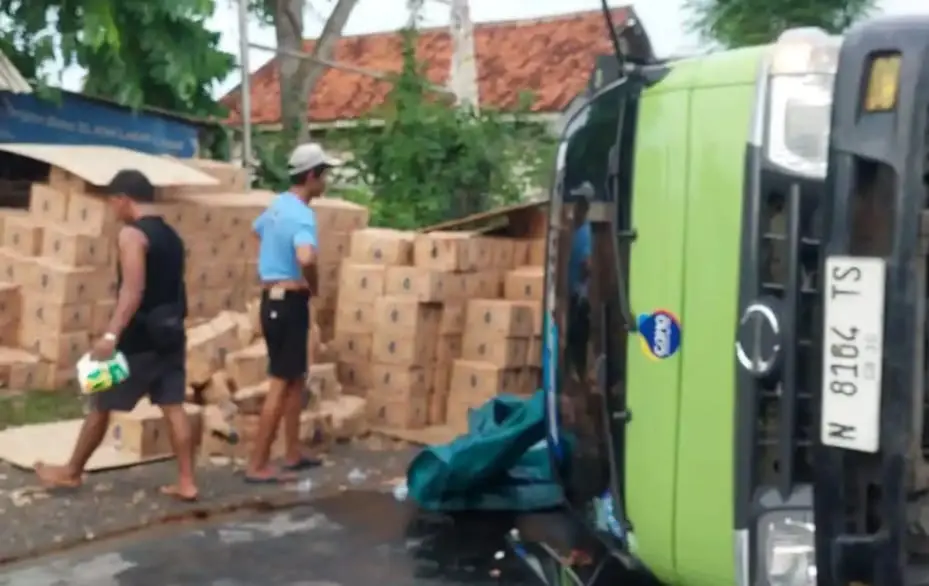 Truk bermuatan air mineral terguling akibat patah as roda di Jalan Raya Bancelok Sampang.