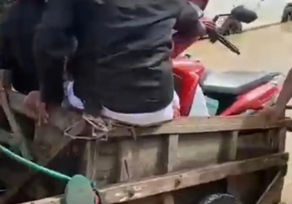 Warga naik gerobak kayu melintasi banjir di Jalan Raya Blega Bangkalan akibat luapan sungai