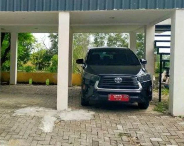 Mobil dinas KPU Sampang Toyota Innova hitam melintas di Tol Waru Surabaya saat libur Lebaran 2026