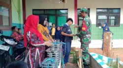 Babinsa Koramil Dasuk saat mengawal pembagian makan bergizi gratis kepada ribuan pelajar dan warga di Sumenep