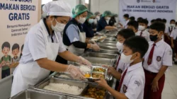 Siswa sekolah menerima makanan gratis dari program Makan Bergizi Gratis sebagai simbol kebijakan sosial pemerintah