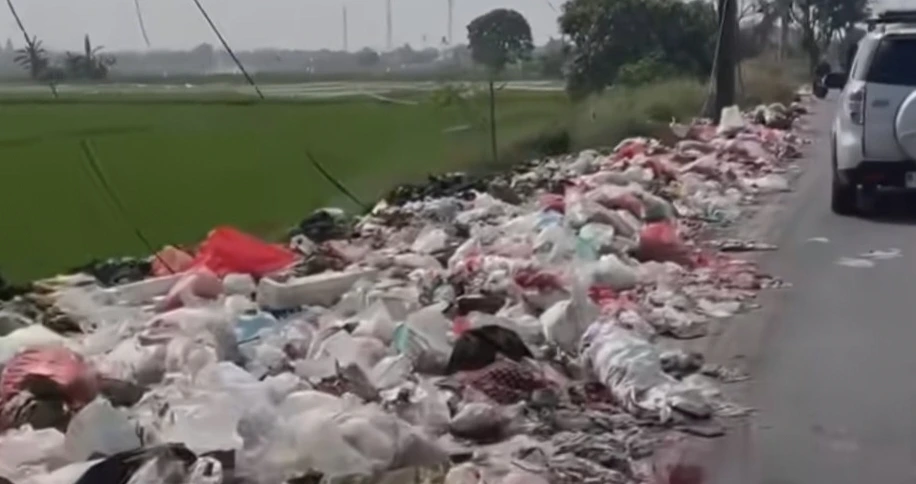 Tumpukan sampah rumah tangga menutupi bahu dan sebagian badan Jalan Raya Kedaung, Kecamatan Babelan, Kabupaten Bekasi.