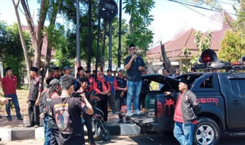 Aktivis menyerahkan rapor merah kepada Kejari Bangkalan dalam aksi Hari Bhakti Adhyaksa untuk mendesak penuntasan dugaan kasus korupsi.