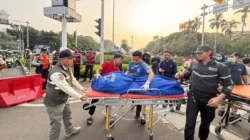 Petugas kepolisian menangani lokasi kecelakaan tunggal yang menewaskan seorang pengemudi ojek online di kawasan Bundaran Patung Kuda, Jakarta Pusat