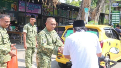 Personel Kodim 0827 Sumenep membagikan nasi kotak kepada masyarakat dalam program Jumat Berkah