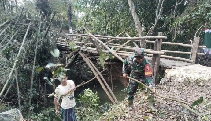 Koramil 0827/03 Manding bersama warga membersihkan lokasi dan mengangkut material pembangunan Jembatan Tahap V di Kecamatan Manding Sumenep