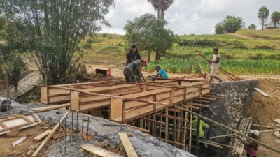 TNI dan warga memasang bekisting pembangunan Jembatan Karang di Desa Mandala, Rubaru.