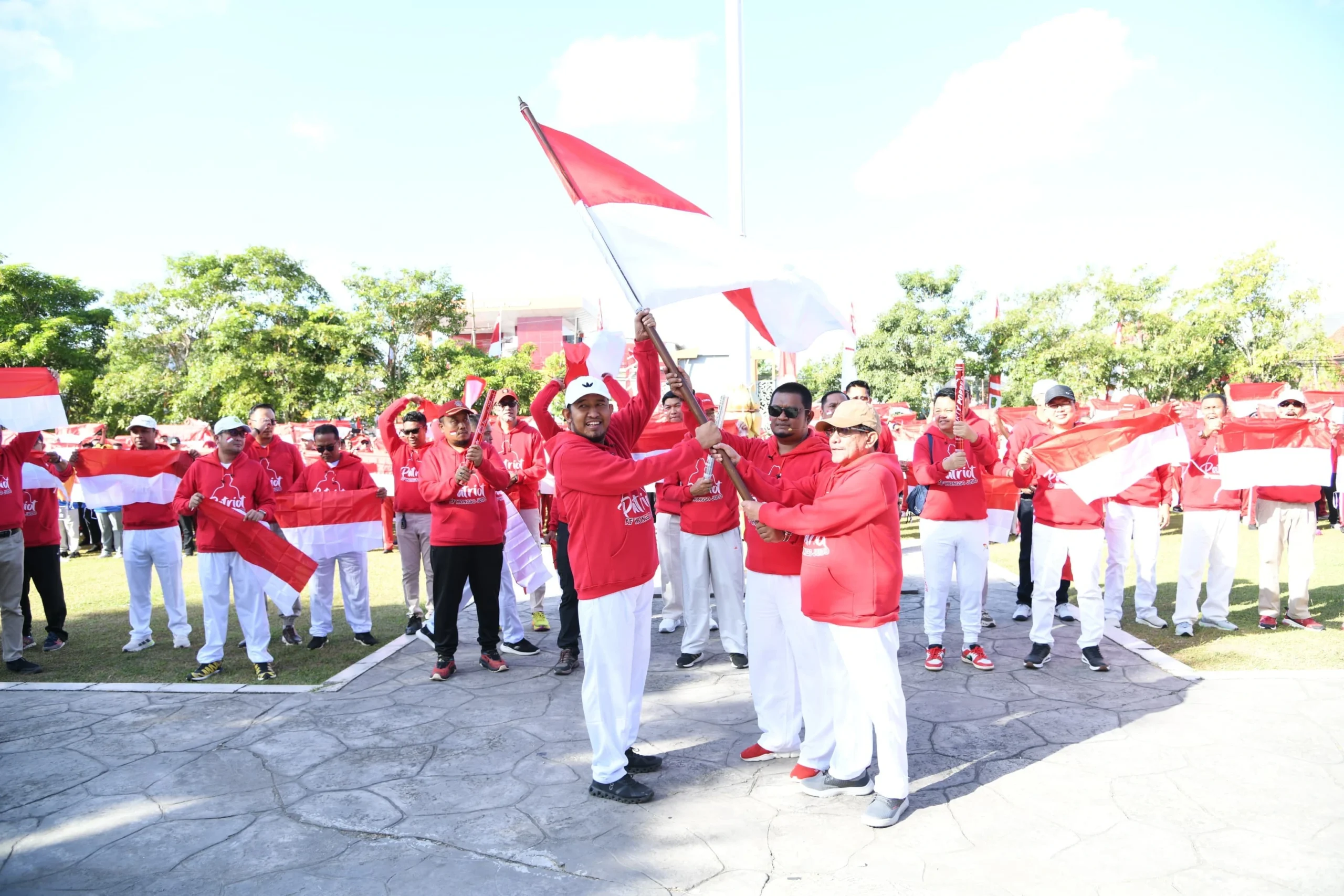 Bupati Sumenep menyerahkan Bendera Merah Putih kepada ASN menjelang HUT Ke-81 RI.