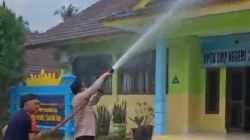 Polisi dan Damkar membersihkan abu vulkanik Gunung Anak Krakatau di SMPN 2 Tanjungsari, Lampung Selatan.