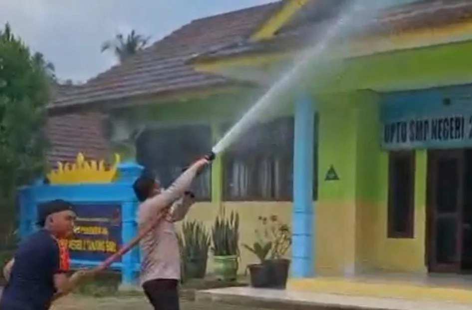 Polisi dan Damkar membersihkan abu vulkanik Gunung Anak Krakatau di SMPN 2 Tanjungsari, Lampung Selatan.