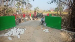 Babinsa Helmi bersama warga mengecat jembatan Desa Lenteng Barat Sumenep