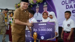 Wabup Bangkalan Moh Fauzan Ja’far menyerahkan hadiah juara Olimpiade Literasi dan Numerasi Bangkalan 2026