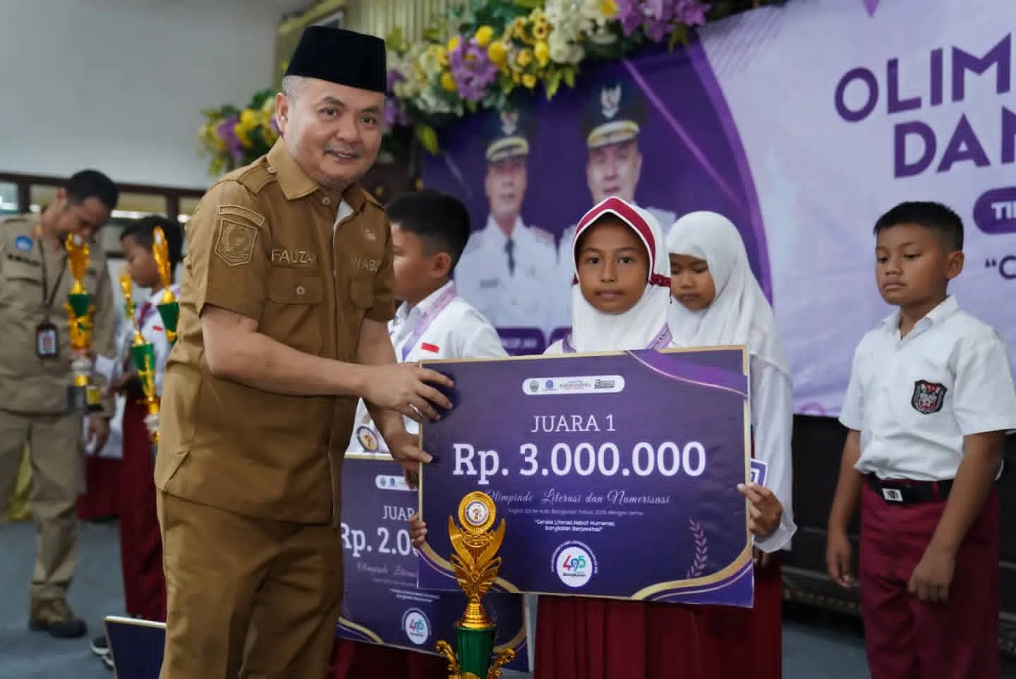 Wabup Bangkalan Moh Fauzan Ja’far menyerahkan hadiah juara Olimpiade Literasi dan Numerasi Bangkalan 2026